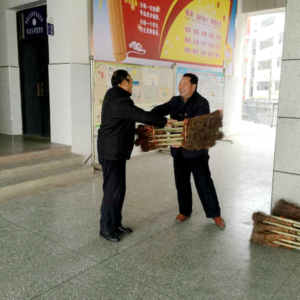 七旬老人扎百把爱心扫帚送学校