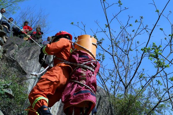 货车冲下山崖 消防群众合力救出两名被困人员